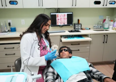 Revive Dental Clinic Child Treatment at Revive Dental Mississauga showing a dentist using a dental model to explain oral care to a young patient.