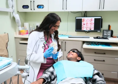 Serving Mississauga with a dentist showing a dental model to a smiling patient at Revive Dental Mississauga.